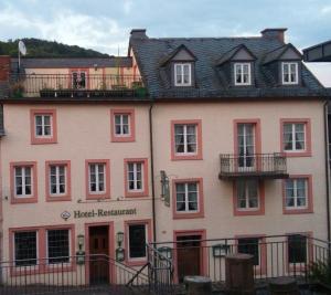 WaxweilerHotel Haus Irsfeld的一座大型粉红色建筑,设有酒店餐厅