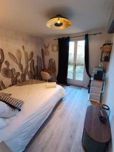 索恩河畔沙隆Le Nid Bourguignon的一间卧室配有一张床、一张桌子和一个窗户。