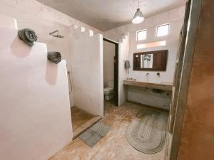 拉穆Lamu penthouse Apartment的一间带水槽、卫生间和镜子的浴室