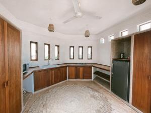 拉穆Lamu penthouse Apartment的厨房配有木制橱柜和吊扇