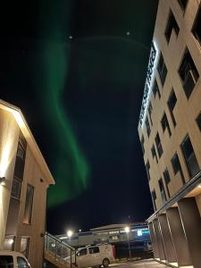 哈默菲斯特Arctic Sea Hotel的在酒店后面的天空中极光的图像
