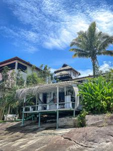 安格拉杜斯雷斯Cabana Do Mar的一座带门廊和棕榈树的房子