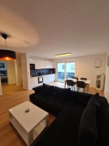 福森Panorama Apartments的客厅配有黑色沙发和桌子
