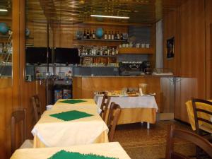 热那亚阿尔伯格博卡戴瑟酒店的餐厅设有两张带绿色餐巾的桌子