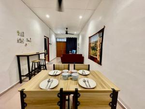 大山脚Cozy 255 Entire 3 Bedroom House At Alma Bukit Mertajam的一间带木桌和椅子的用餐室