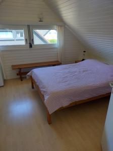 米德尔克尔克Seaside的一间卧室配有一张床、一张长凳和一个窗户。