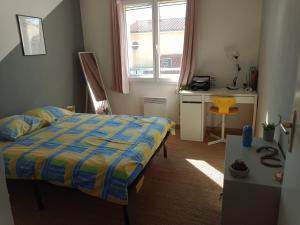 佩皮尼昂Villa perpignanaise的一间卧室配有一张床、一张书桌和一个窗户。