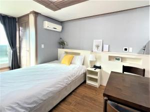 西归浦市HY Choi Hostel的一间卧室配有一张床、一张桌子和一张桌子