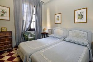 佛罗伦萨Palazzo Panzani的一间卧室配有一张床、一个梳妆台和一扇窗户。