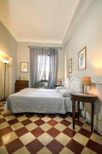 佛罗伦萨Palazzo Panzani的一间卧室配有一张大床和一张桌子