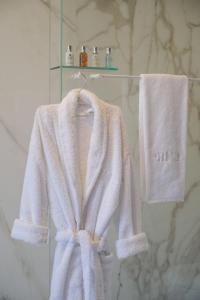 塞图巴尔RM The Experience - Small Portuguese Hotels的浴室内的一个白色浴袍和毛巾架