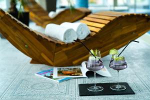 AjkaHotel Kristály Konferencia & Wellness的一张桌子,上面放着两杯葡萄酒和一艘船