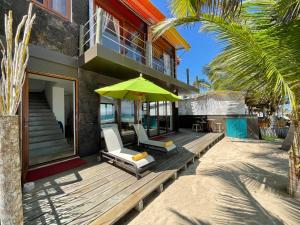 比亚米尔港Mi Playa Beach Front Isabela的房屋设有2把椅子和1把遮阳伞的甲板