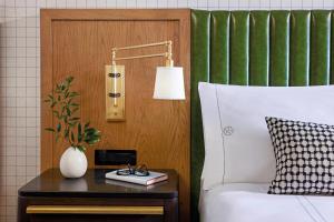弗赖拉辛Omni PGA Resort Frisco-Dallas的一间卧室配有一张床和一张带台灯的桌子