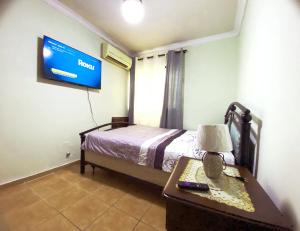 圣多明各Amplio apartamento en Gazcue SDQ的一间卧室配有一张床、一张桌子和一台电视。