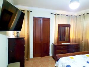 圣多明各Amplio apartamento en Gazcue SDQ的一间卧室配有一张床、梳妆台和电视。