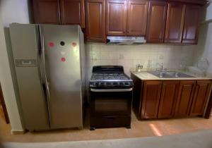 圣多明各Amplio apartamento en Gazcue SDQ的厨房配有不锈钢冰箱和炉灶。