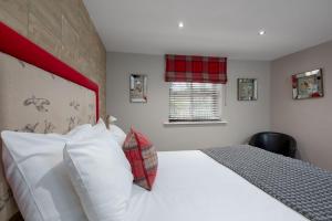 北安普敦The World's End - Northampton的一间卧室配有一张白色大床和红色床头板