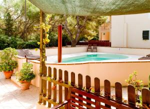 埃斯卡洛Apartamentos El Pino - Formentera Break的庭院设有热水浴池和围栏