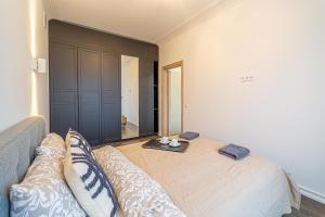 考纳斯Žalgiris arena apartment with AC的一间卧室配有一张床、一张沙发和一面镜子