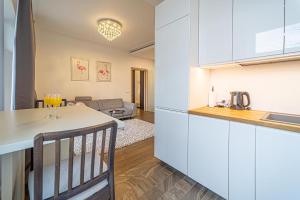 考纳斯Žalgiris arena apartment with AC的厨房以及带白色橱柜和桌子的客厅。