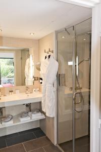 卡布尔Thalazur Cabourg - Hôtel & Spa的带淋浴和白色浴袍的浴室