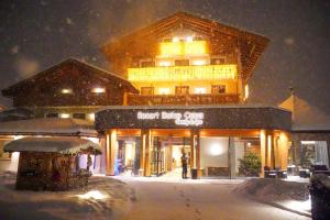 莫埃纳Resort Dolce Casa - Family & Spa Hotel的一座大建筑物,在晚上下雪