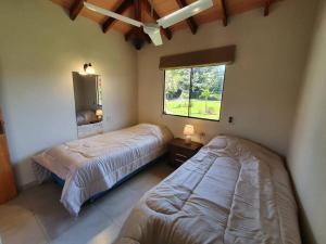圣贝纳迪诺Casa con Piscina, Quincho, Cancha de Futbol/Volley的一间卧室设有两张床和窗户。