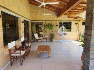 圣贝纳迪诺Casa con Piscina, Quincho, Cancha de Futbol/Volley的一个带桌椅和风扇的庭院