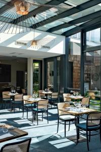 卡布尔Thalazur Cabourg - Hôtel & Spa的餐厅设有桌椅和窗户。