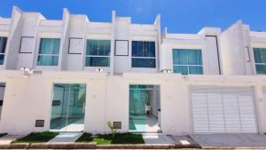 塞古罗港Apartamento a 400 metros da praia de taparapuan的白色的房子,设有车库