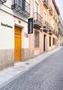 马德里limehome Madrid San Lorenzo的一条在大楼上设有黄色门的街道