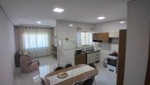 伊瓜苏Casa aconchegante com piscina e bem localizada的厨房配有桌椅和冰箱。