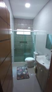 伊瓜苏Casa aconchegante com piscina e bem localizada的一间带卫生间和玻璃淋浴间的浴室