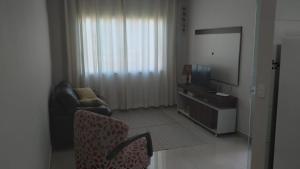 伊瓜苏Casa aconchegante com piscina e bem localizada的客厅配有椅子和电视