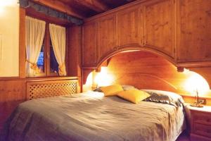 圣维托-迪卡多雷Mansarda su due livelli nel cuore delle Dolomiti的一间卧室配有一张带两个黄色枕头的大木床