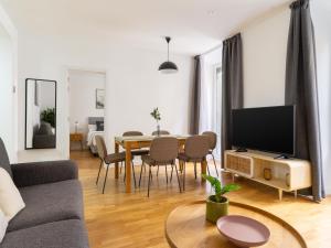 马德里limehome Madrid San Lorenzo的客厅配有沙发和带电视的桌子