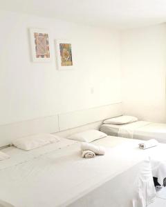 马塞约马塞约海滨宾馆的白色墙壁的客房内的三张床
