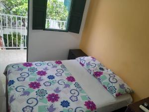 比利亚维哈CASA FLOR DE LIZ的一间卧室配有一张带鲜花床单的床和窗户。