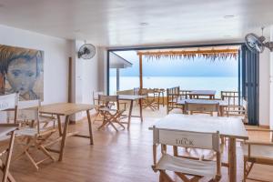 波普托里维埃拉海滩酒店的一间带桌椅的用餐室和一幅画