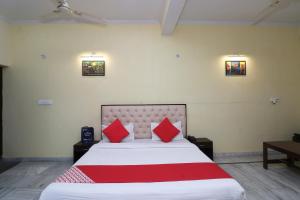 巴雷利OYO Hotel Ayaan的一间卧室配有一张带红色枕头的大床