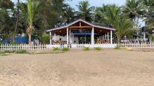 戈卡尔纳Vibes and Tides Beach Resort by Enlightened Vagabond的棕榈树掩映的海滩上的凉亭