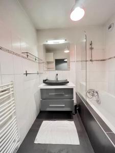 兰斯Lagrive - avec VUE panoramique的白色的浴室设有水槽和浴缸。