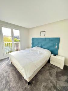 兰斯Lagrive - avec VUE panoramique的一间卧室配有一张大床和蓝色床头板