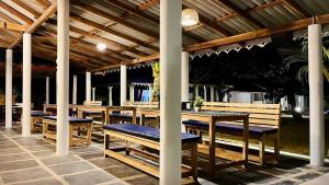 戈卡尔纳Vibes and Tides Beach Resort by Enlightened Vagabond的一间带木桌和蓝色长椅的餐厅