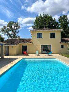 尚塞拉德Maison de vacances avec piscine的一座大蓝色游泳池,位于房子前