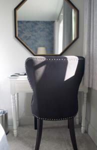奥尔顿The Binsted Inn的一张黑椅,坐在一张桌子前,带镜子