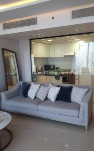 利雅德شقة خاصة برج رافال的客厅设有蓝色沙发,厨房设有
