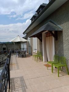 IbosLa POSADA的一个带绿色椅子、桌子和遮阳伞的庭院