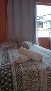 伦索伊斯Pousada Casa da Neuzita的一间卧室配有两张带毛巾的床